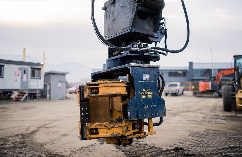 Detailed image of sonic vibro head used to install 30' steel sheet piles for a 50m-long shoring wall at the Hampton Hotel site in Kelowna, BC.