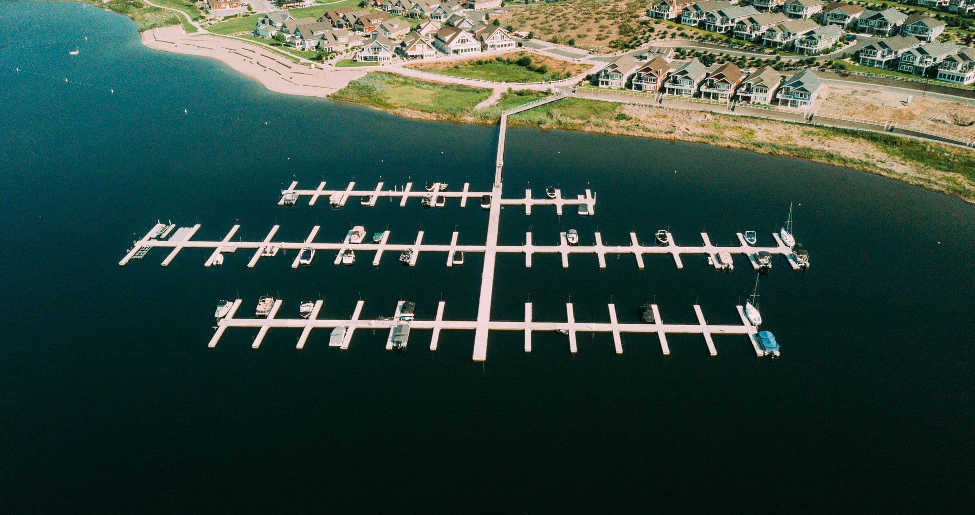 Aerial view of a completed marina in Osoyoos, BC, featuring modern dock systems and moored boats—part of Burton Marine's commercial waterfront infrastructure services.