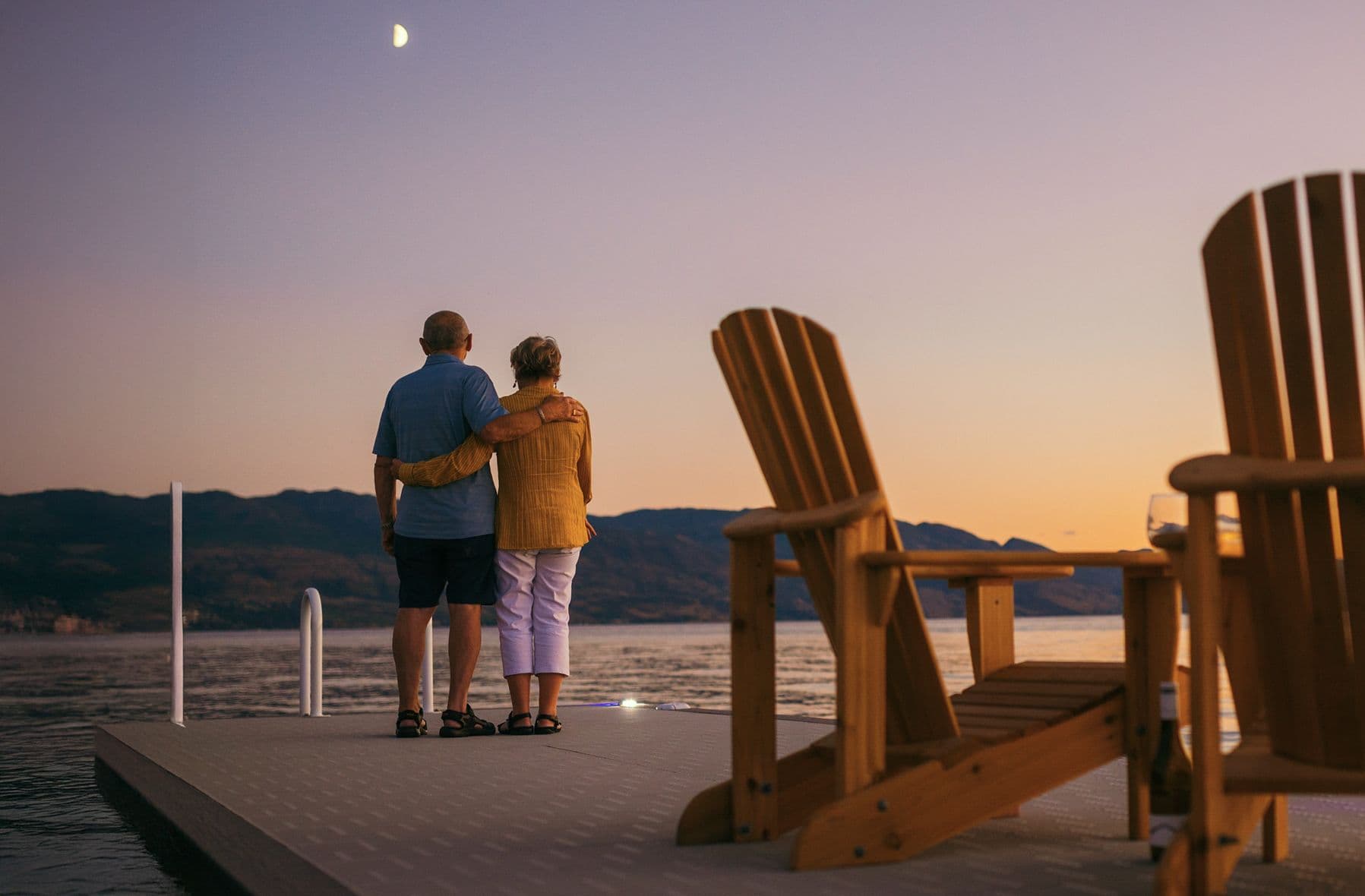 Retired couple standing on a custom-built dock in Kelowna, BC at sunset—showcasing premium dock design built for longevity, safety, and relaxation.