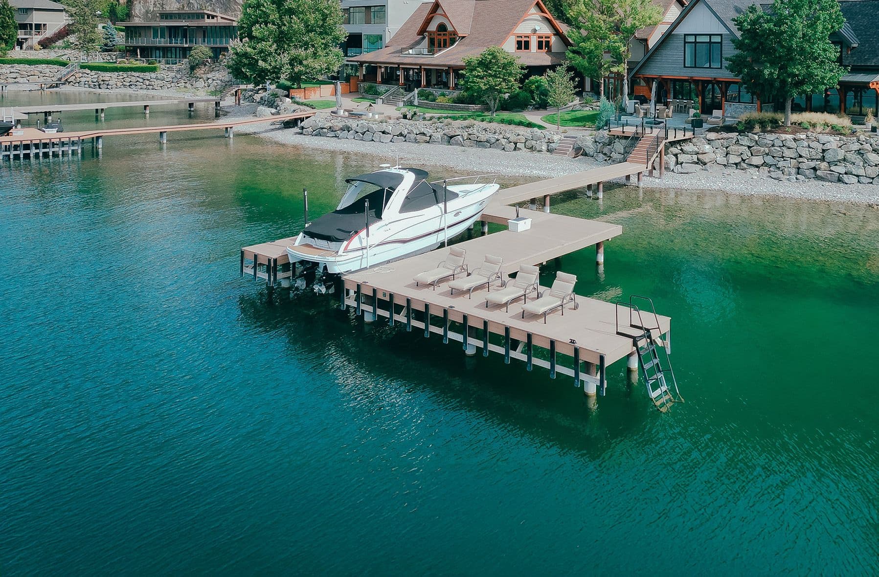 Contemporary dock design with lounge seating and luxury boat moorage, featuring composite decking and aluminum framing