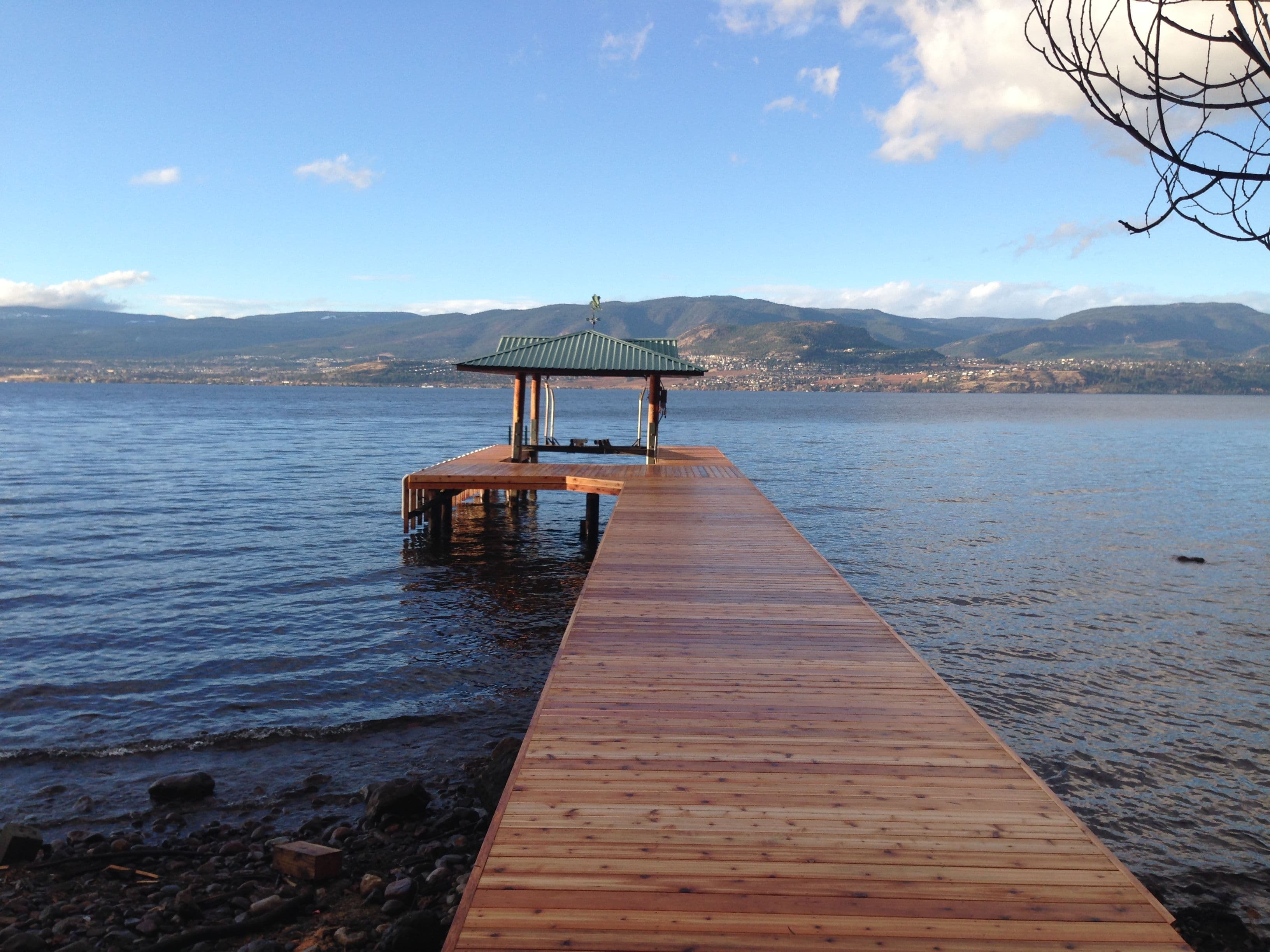 Rebuilt dock with extended cedar decking and covered platform on Okanagan Lake, fully restored for long-term durability and lakeside enjoyment.