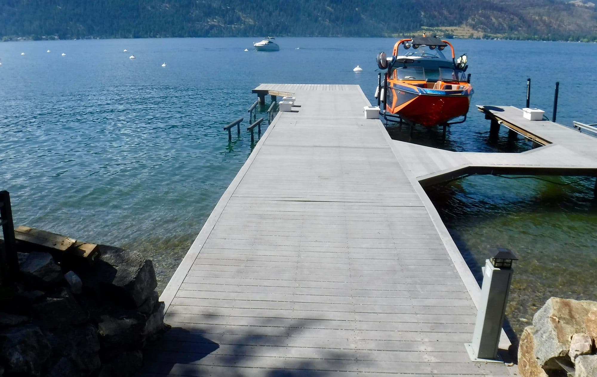 Older residential dock on Okanagan Lake with aging wood decking and basic boat lift, ready for a full replacement to improve durability and functionality.
